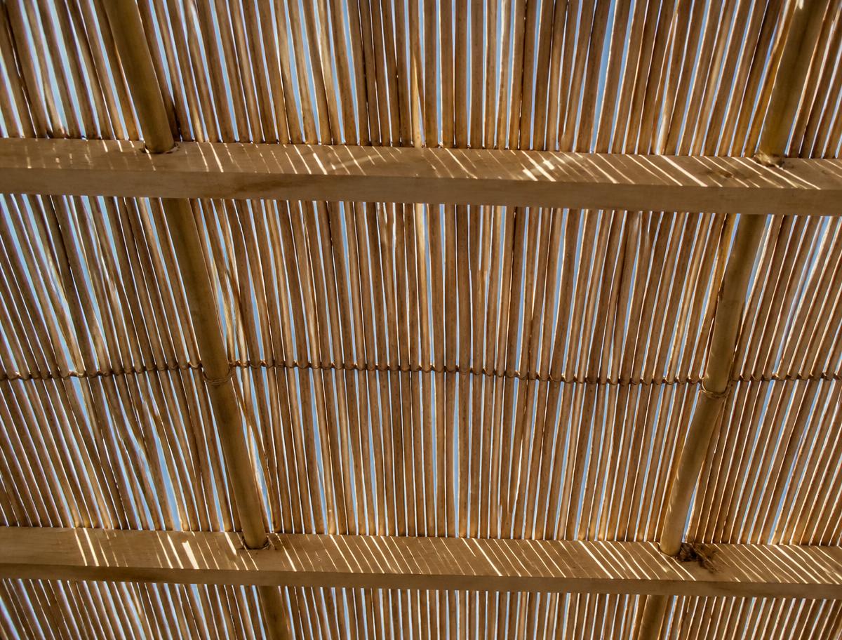Bamboo schach roof seen from directly underneath with sunlight filtering through